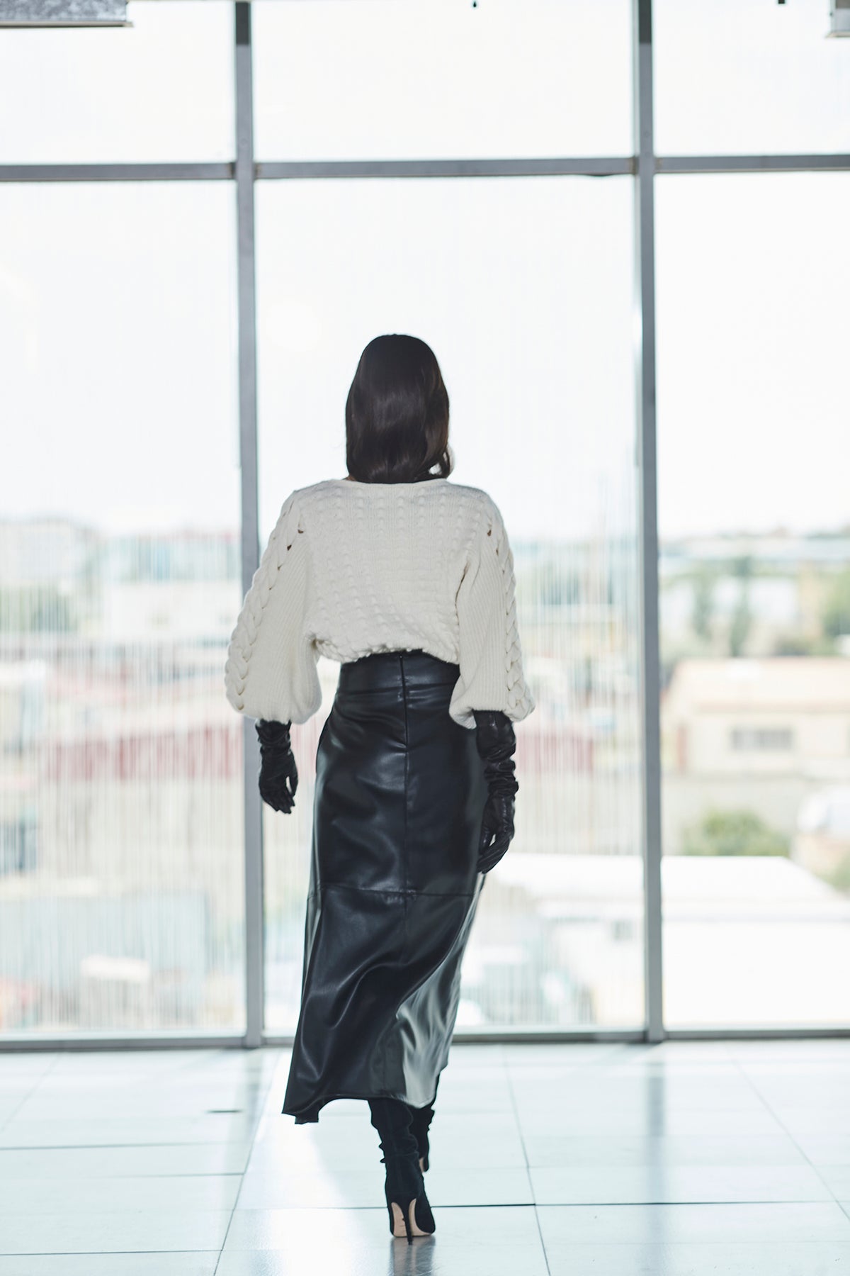 Falda midi ecopiel negra de cintura alta con efecto piel y un cautivador tono profundo. Elegancia, audacia y versatilidad.