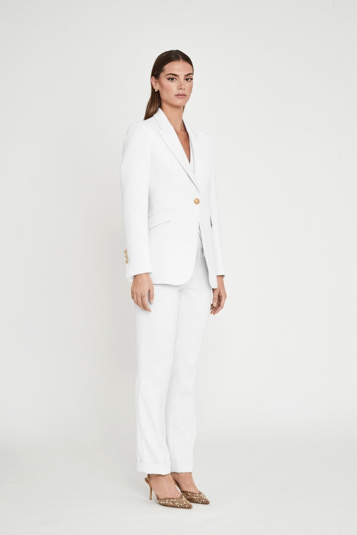Blazer entallada blanca Paris de super crepe con solapa de pico, botón metálico dorado y bolsillos de cartera. Elegancia artesanal y sostenible.