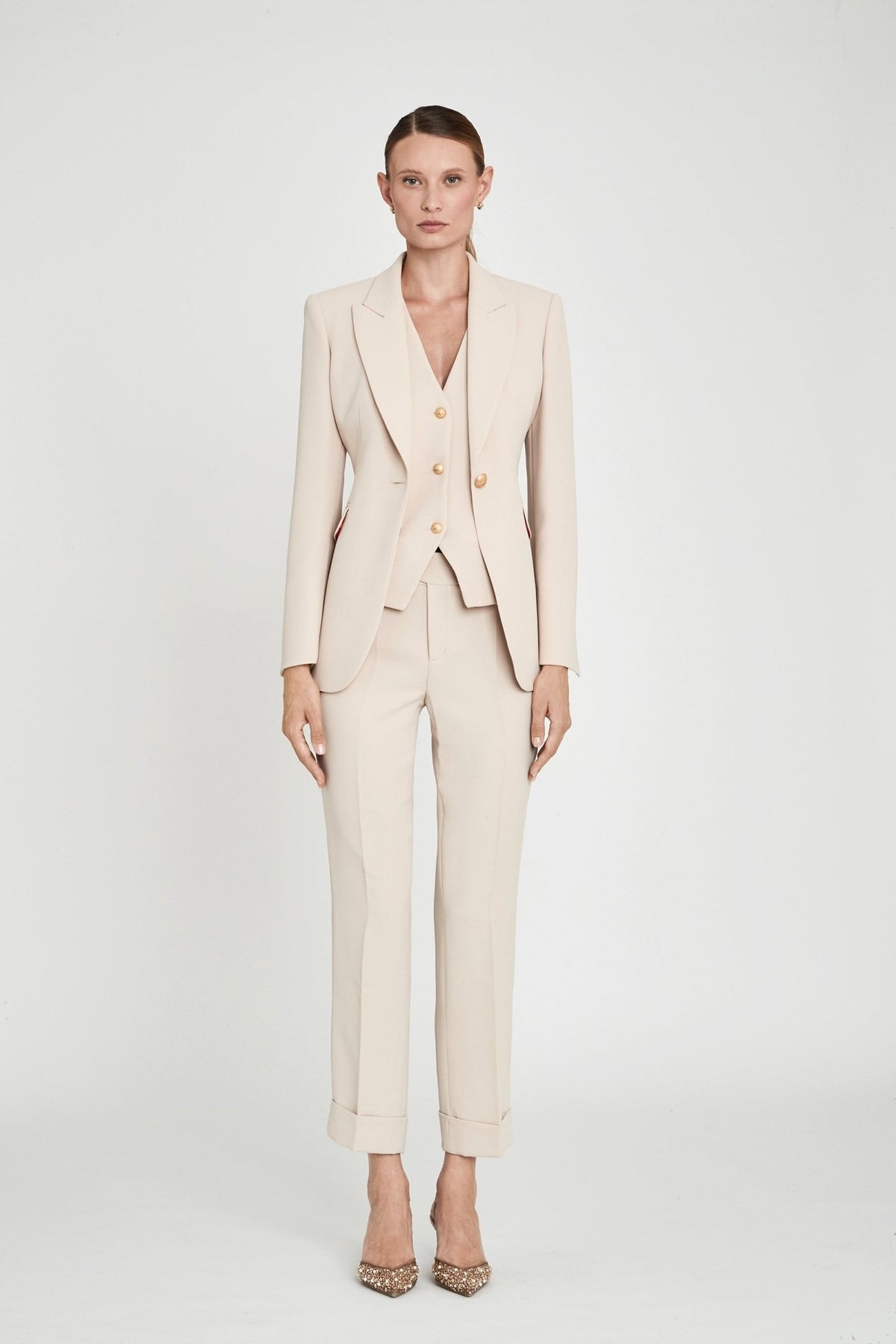 Blazer entallada beige Paris de tejido liso en tono tofe con solapa clásica, botón dorado central y estructura impecable.