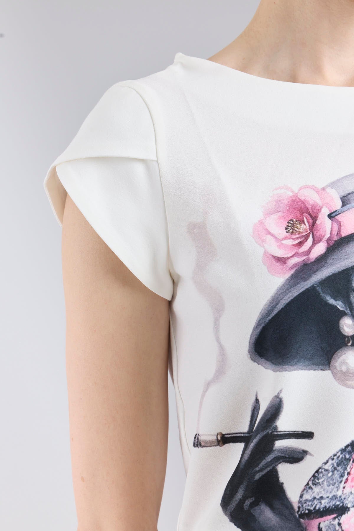 Camiseta estampada blanco Camelia de corte fluido con mangas en forma de pétalo y elegante ilustración frontal.