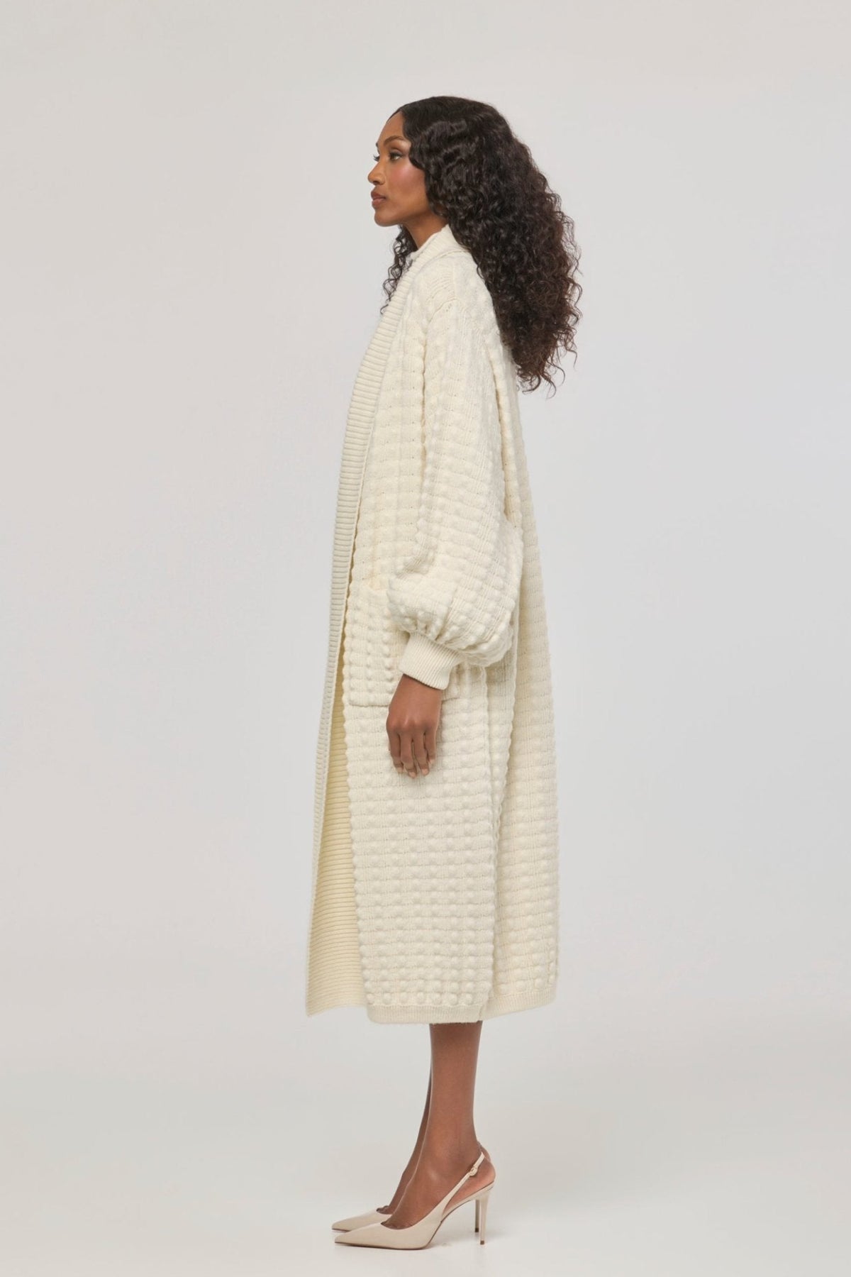 Cárdigan largo de punto blanco blanco para mujer con mangas de textura geométrica y diseño minimalista.