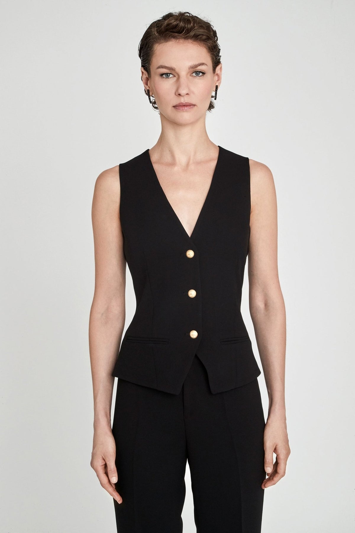 Chaleco sastre negro Atelier en super crepé de tres botones con bolsillos de vivo y detalles dorados con logo.