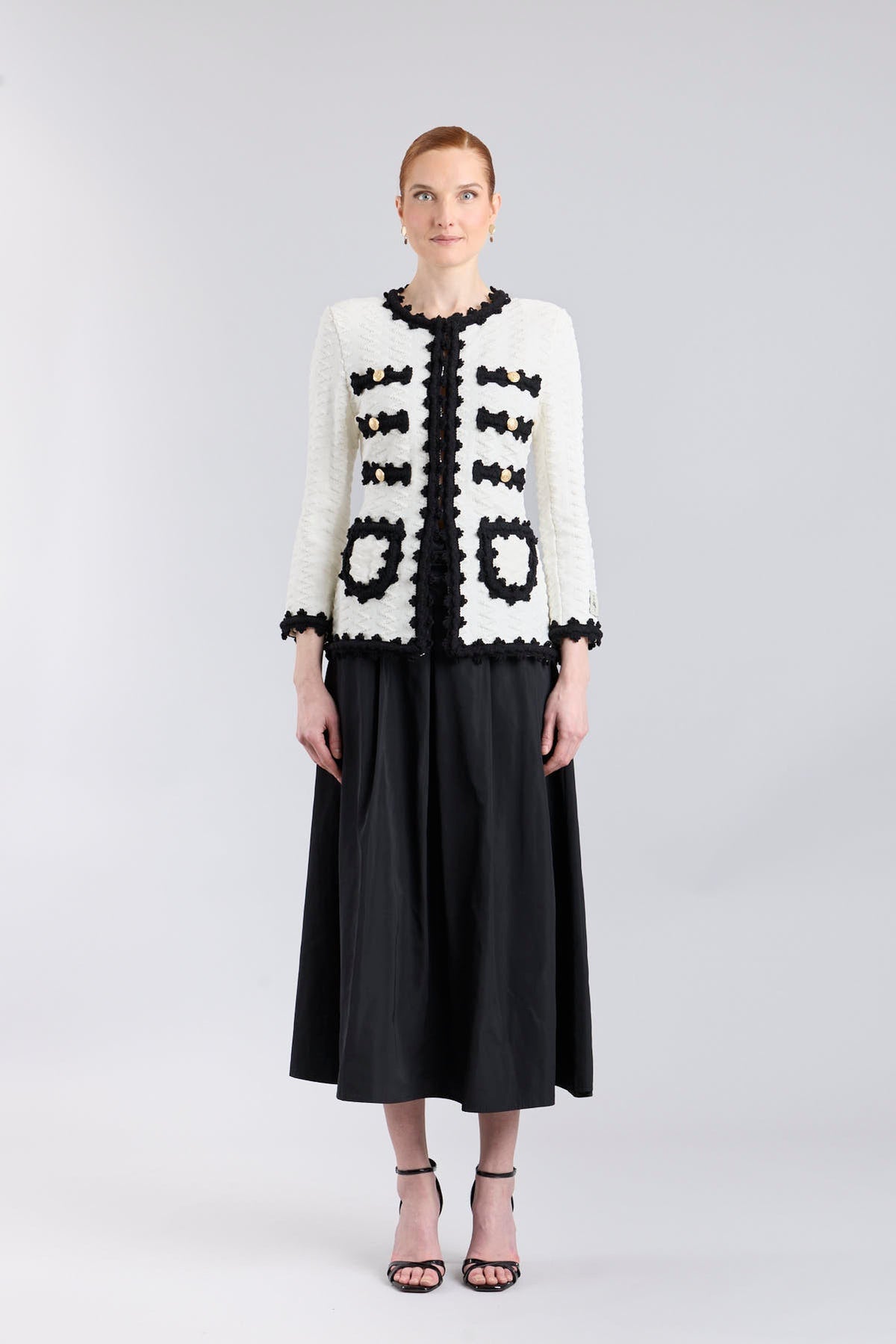 Chaqueta de punto para mujer modelo Oliver en blanco con vivos y bolsillos en negro.
