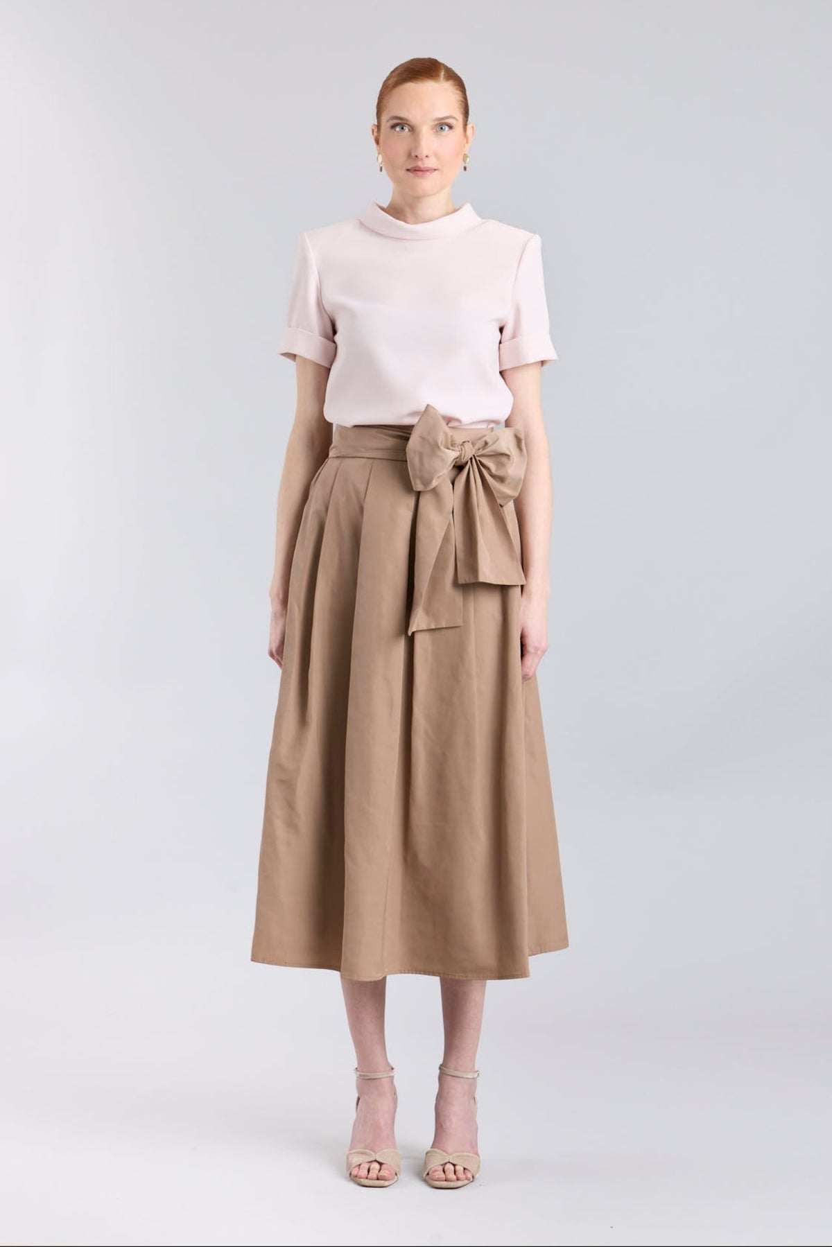 Falda midi color camel con volumen y detalle de lazo en la cintura de The Extreme Collection.