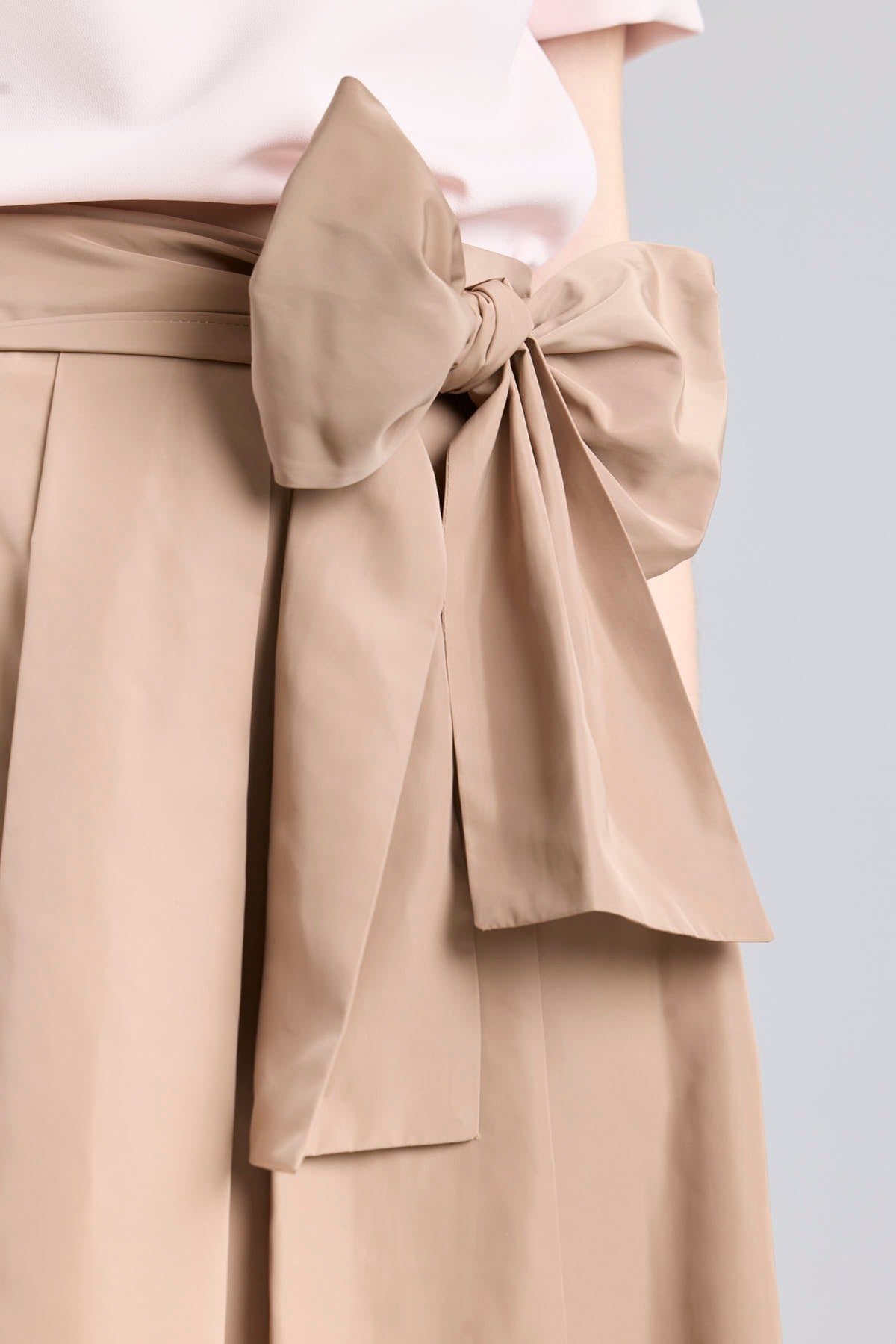 Falda midi color camel con volumen y detalle de lazo en la cintura de The Extreme Collection.