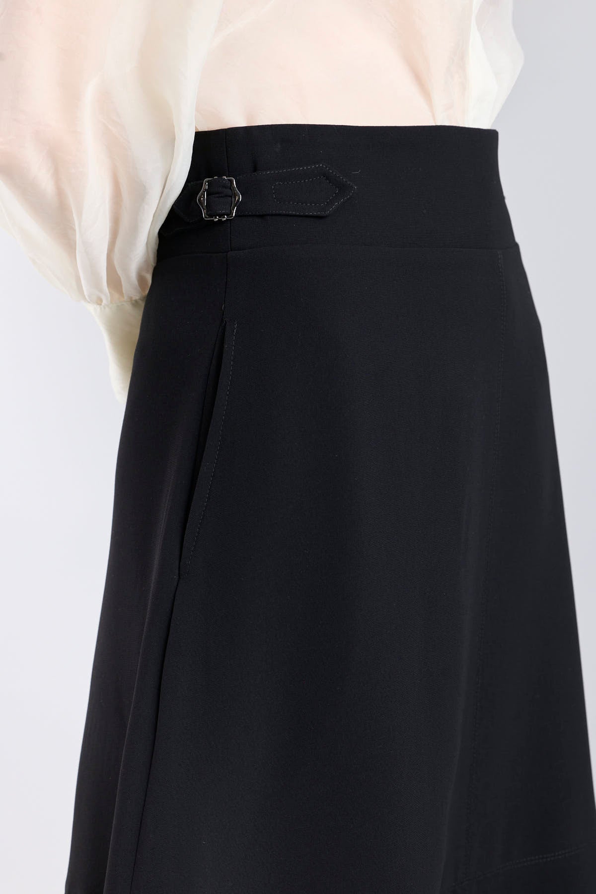 Falda midi de corte evasé color negro con detalle de hebillas en la cintura de The Extreme Collection.