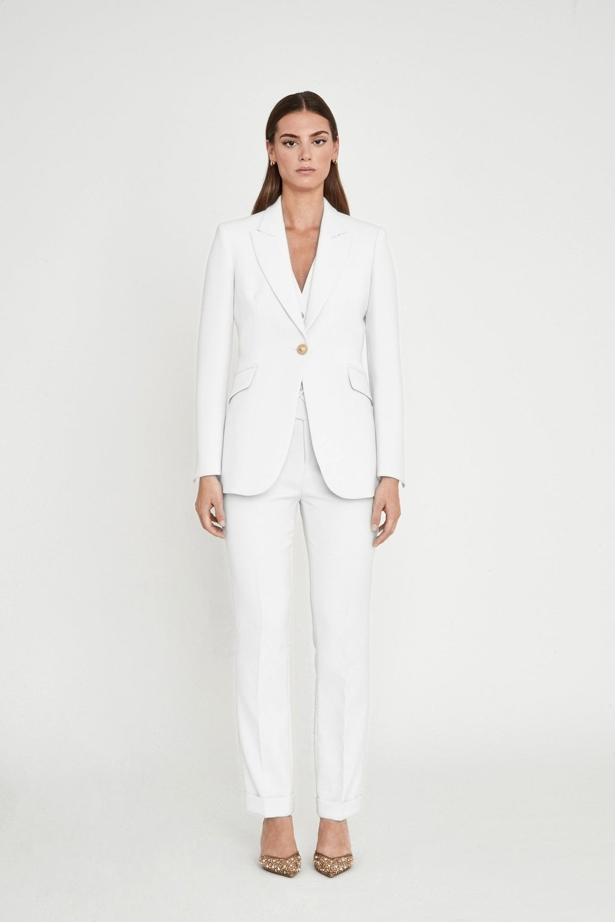 Blazer entallada blanca Paris de super crepe con solapa de pico, botón metálico dorado y bolsillos de cartera. Elegancia artesanal y sostenible.