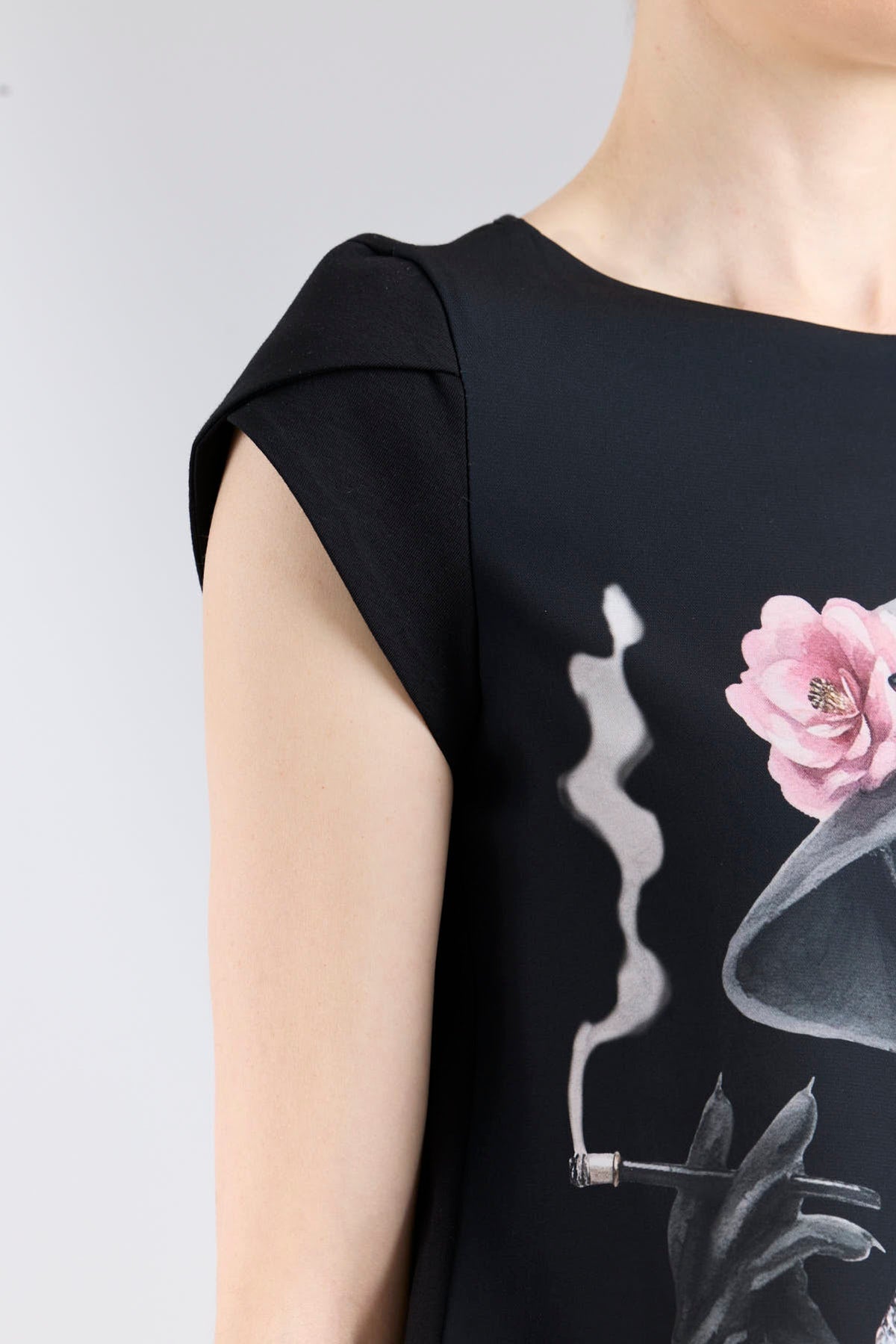 Camiseta estampada negra Camelia de silueta fluida con mangas en forma de pétalo y elegante ilustración frontal.