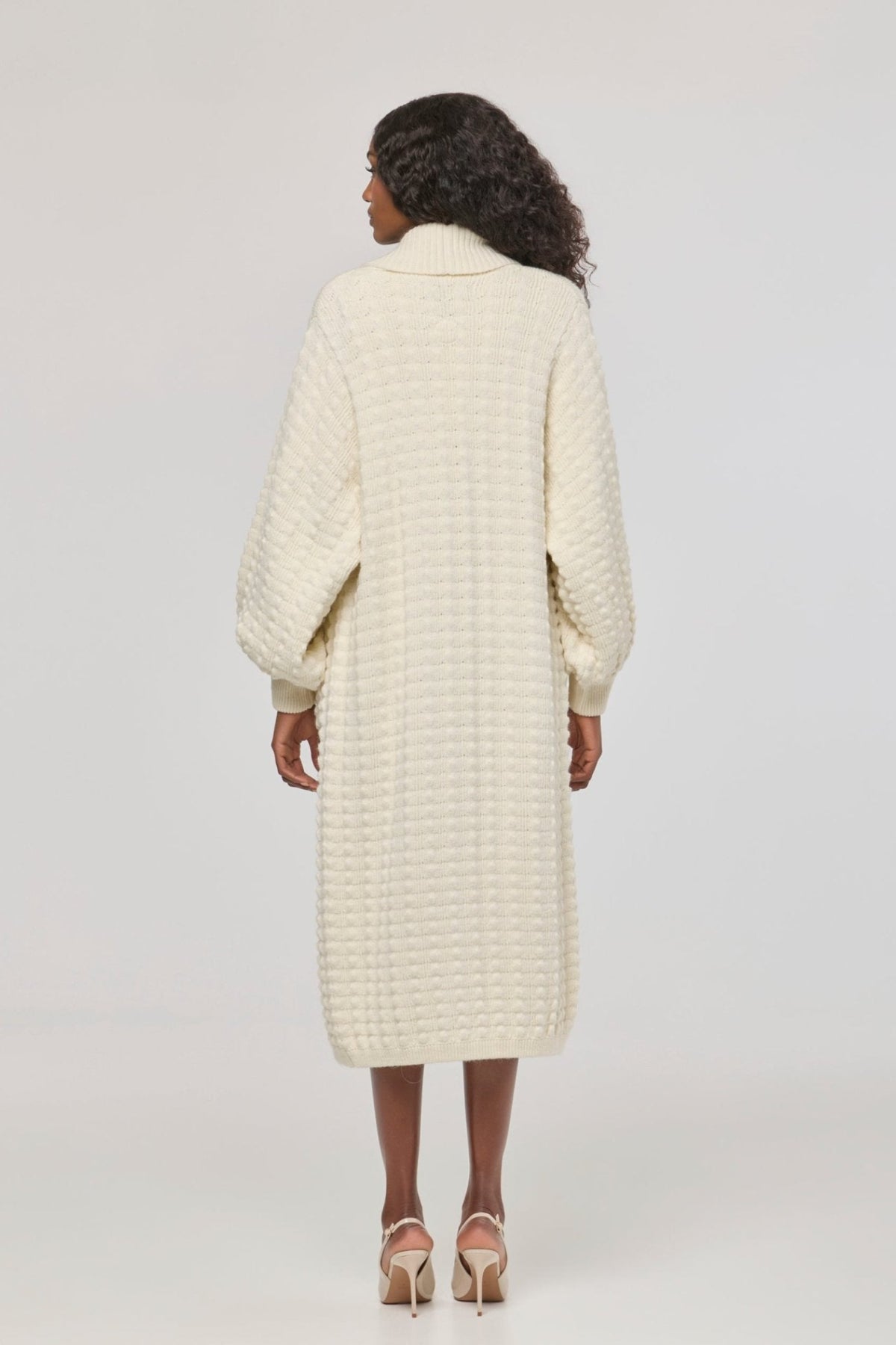 Cárdigan largo de punto blanco blanco para mujer con mangas de textura geométrica y diseño minimalista.