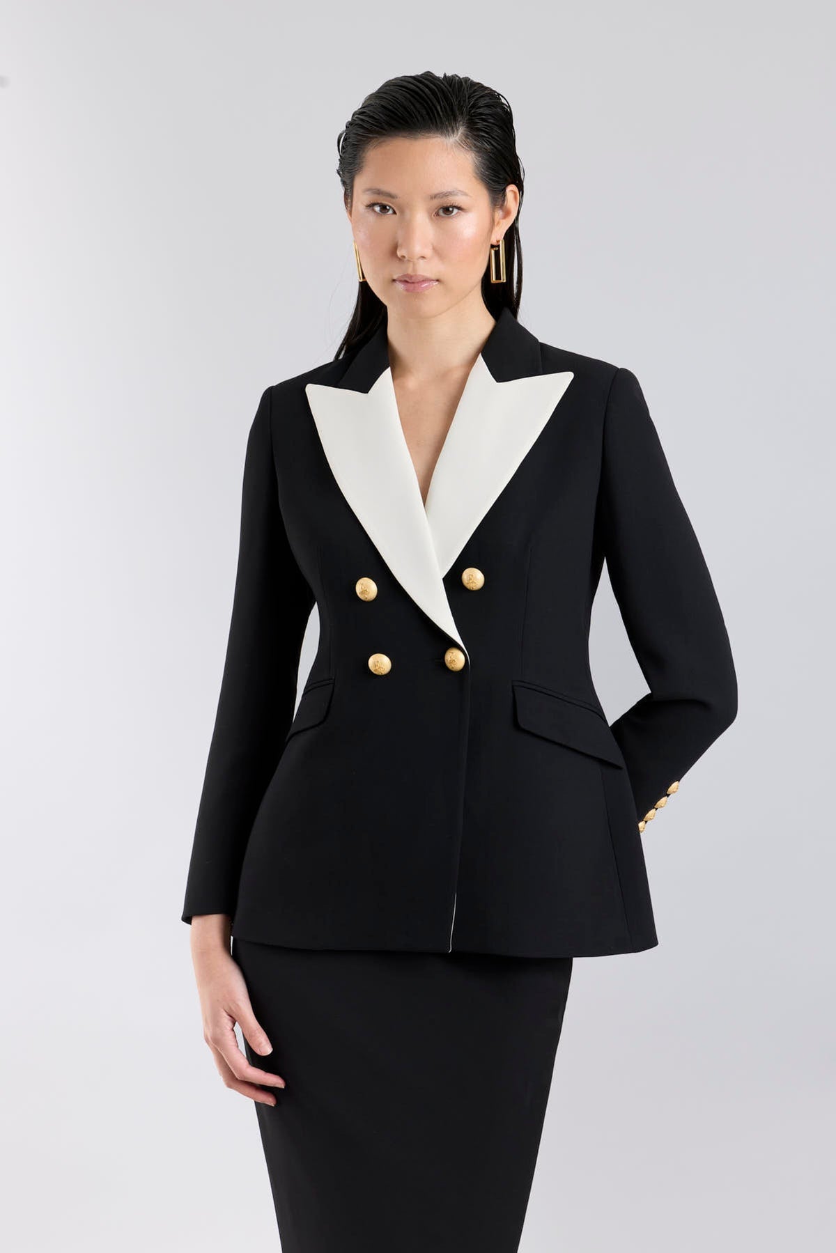 Chaqueta blazer de diseño cruzada en negro con solapas de pico blancas para mujer modelo Iconic Code 01.