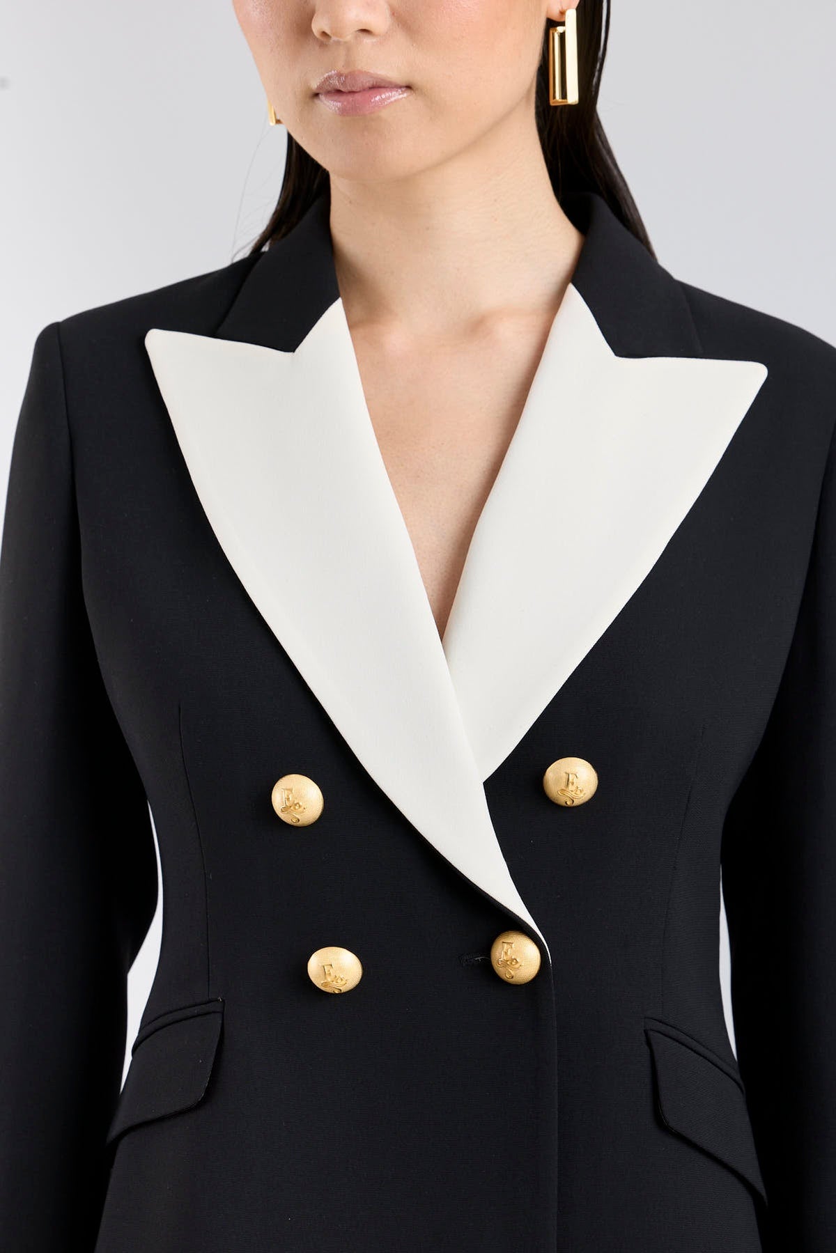 Chaqueta blazer de diseño cruzada en negro con solapas de pico blancas para mujer modelo Iconic Code 01.