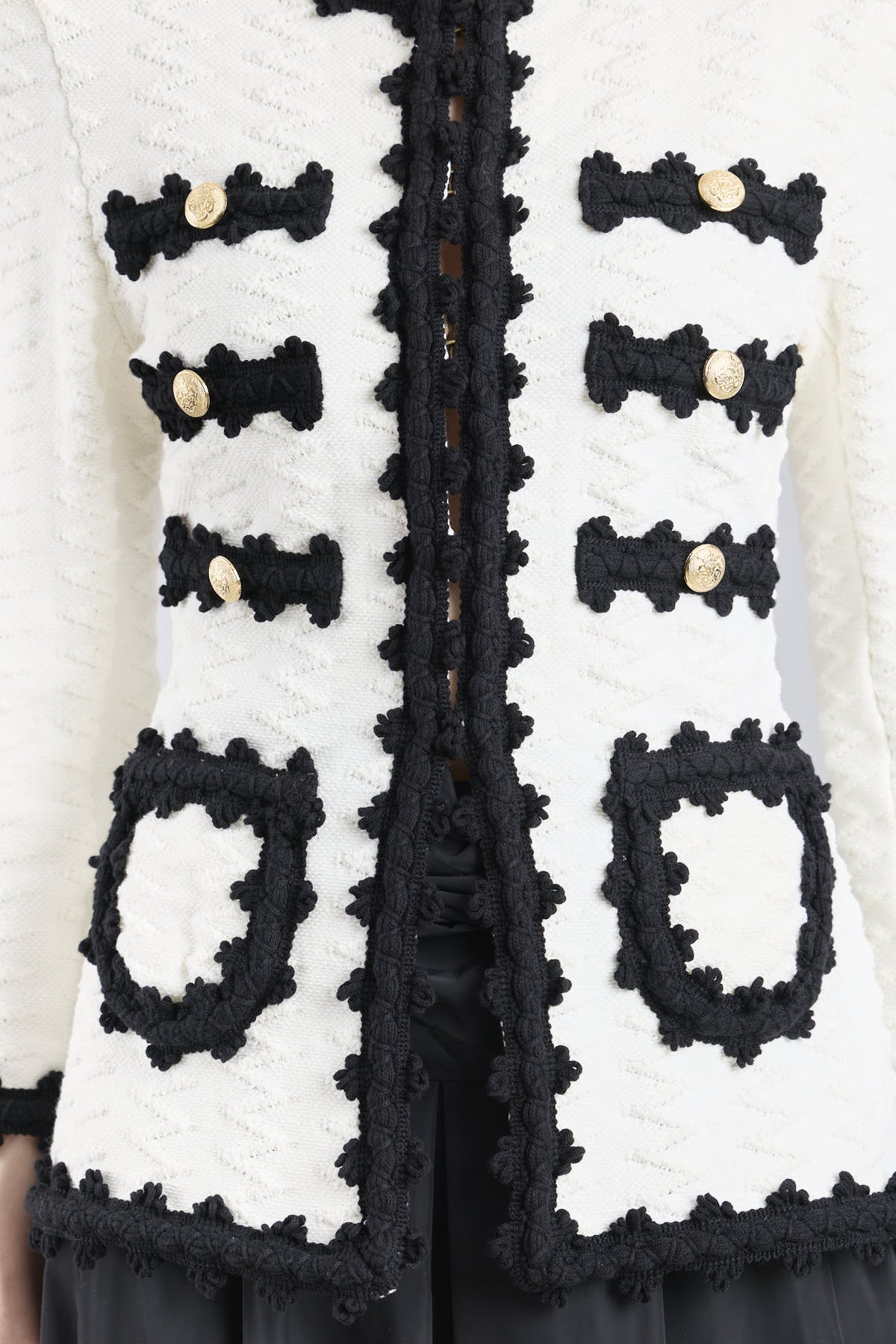 Chaqueta de punto para mujer modelo Oliver en blanco con vivos y bolsillos en negro.