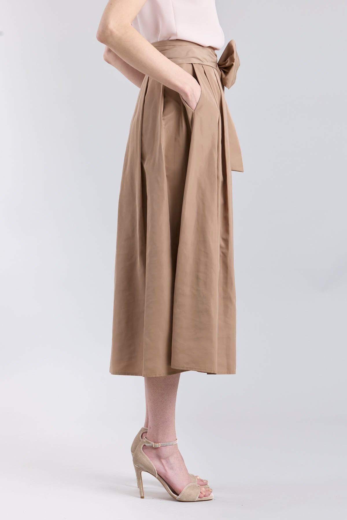 Falda midi color camel con volumen y detalle de lazo en la cintura de The Extreme Collection.